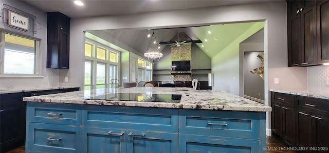 17078 S 11th W Ave, Glenpool, OK 74033 - kitchen featuring black electric stovetop, backsplash, vaulted ceiling, blue cabinets, and light stone countertops