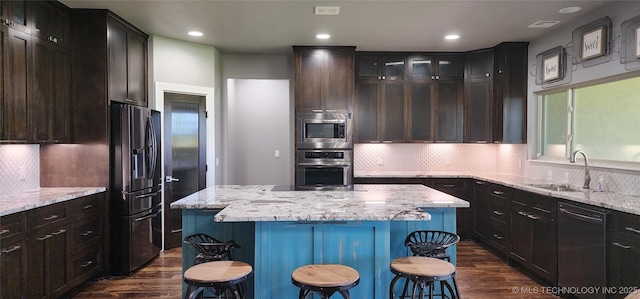 17078 S 11th W Ave, Glenpool, OK 74033 - kitchen featuring appliances with stainless steel finishes, dark wood-style floors, a center island, backsplash, and recessed lighting