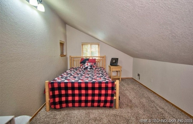 carpeted bedroom with a textured wall, lofted ceiling, a textured ceiling, and visible vents