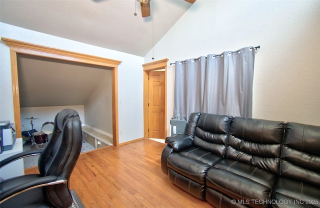 office area featuring baseboards, lofted ceiling, light wood-style flooring, and ceiling fan