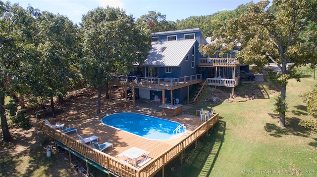 view of swimming pool with stairs, a wooden deck, a fenced in pool, a yard, and a patio area
