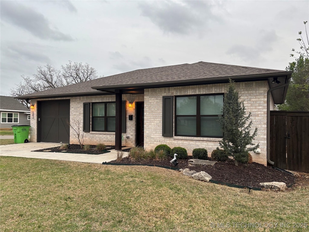 502 W 8th Ave, Bristow, OK 74010 - view of front of property with brick siding, a shingled roof, concrete driveway, and a front yard