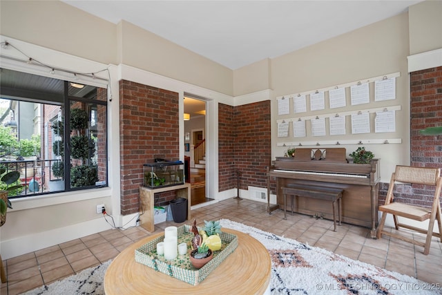 1225 E 18th St, Tulsa, OK 74120 - tiled living area featuring baseboards and brick wall