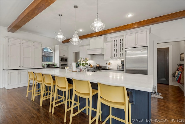 1225 E 18th St, Tulsa, OK 74120 - kitchen with appliances with stainless steel finishes, beamed ceiling, tasteful backsplash, dark wood-style floors, and white cabinets