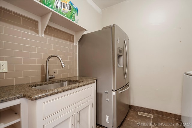 1225 E 18th St, Tulsa, OK 74120 - kitchen with a sink, stainless steel refrigerator with ice dispenser, tasteful backsplash, white cabinetry, and dark stone countertops