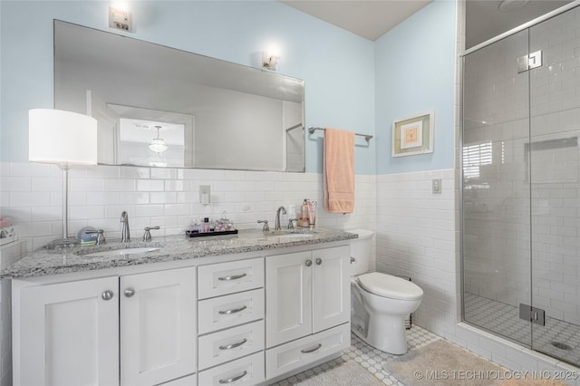 1225 E 18th St, Tulsa, OK 74120 - full bathroom with tile walls, a shower stall, toilet, double vanity, and tile patterned floors
