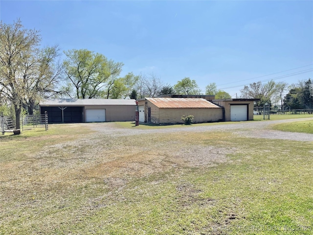 view of yard featuring fence, an outbuilding, an outdoor structure, and a garage