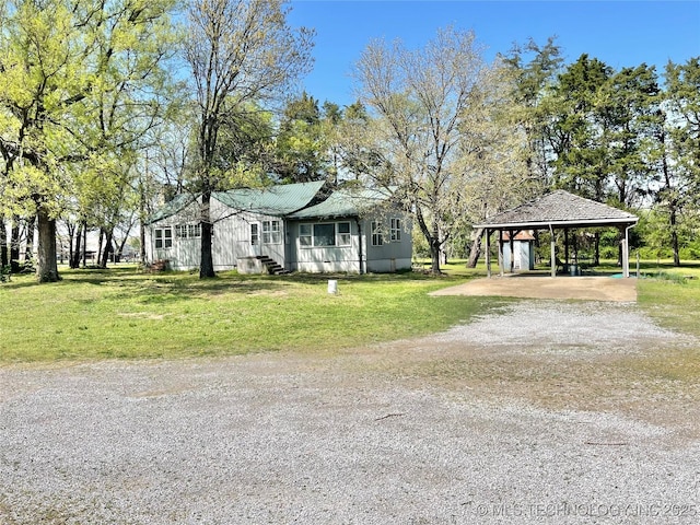 view of front of home featuring a front yard, a carport, and dirt driveway