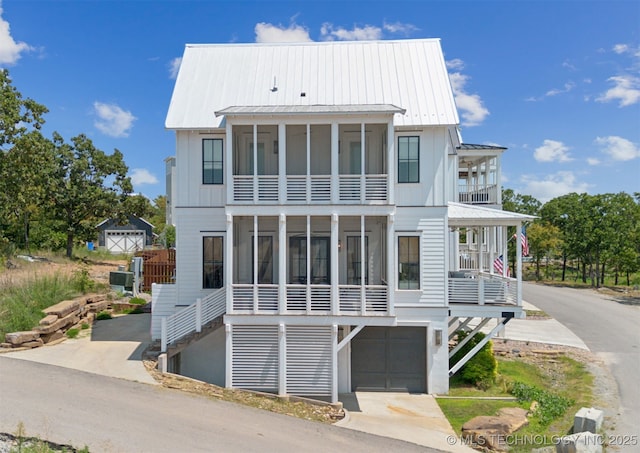 101 Lower Greenway, Carlton Landing, OK 74432 - raised beach house with board and batten siding, a sunroom, a garage, and metal roof