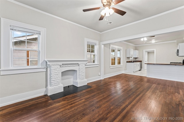 unfurnished living room with crown molding, a ceiling fan, baseboards, visible vents, and hardwood / wood-style floors