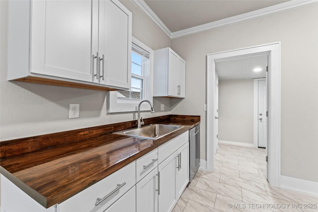 kitchen with white cabinetry, crown molding, stainless steel dishwasher, a sink, and wood counters
