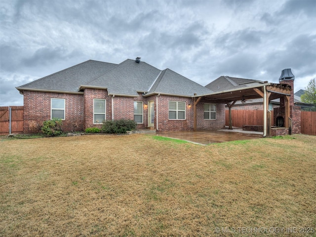 back of house featuring a fenced backyard, a lawn, a patio, and roof with shingles