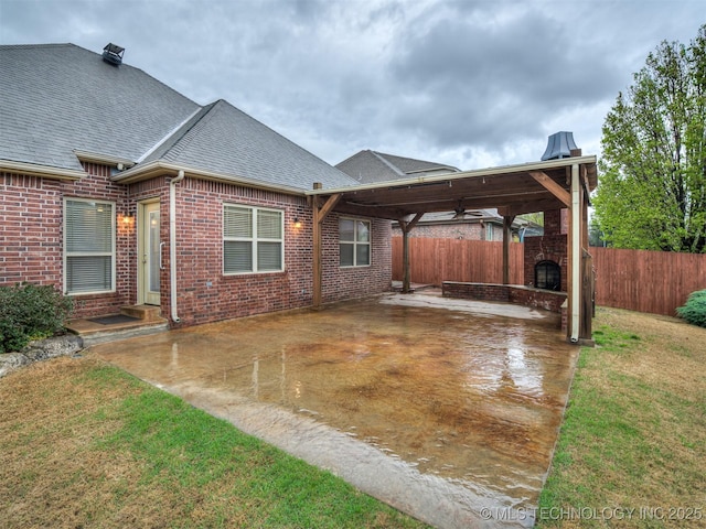 exterior space featuring brick siding, a shingled roof, a carport, and a patio area
