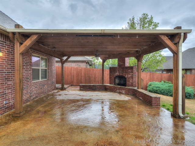view of patio / terrace with an outdoor brick fireplace and fence