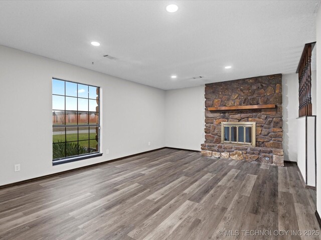 208 NE Spruce Ave, Bartlesville, OK 74006 - unfurnished living room with baseboards, a fireplace, wood finished floors, and recessed lighting