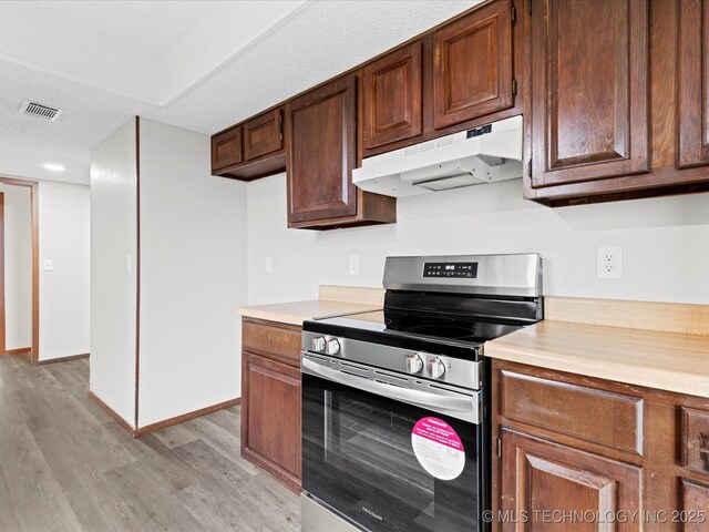 208 NE Spruce Ave, Bartlesville, OK 74006 - kitchen featuring under cabinet range hood, light countertops, visible vents, and electric range