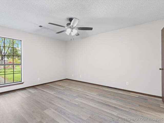 208 NE Spruce Ave, Bartlesville, OK 74006 - unfurnished room with a ceiling fan, a textured ceiling, light wood-style flooring, baseboards, and visible vents