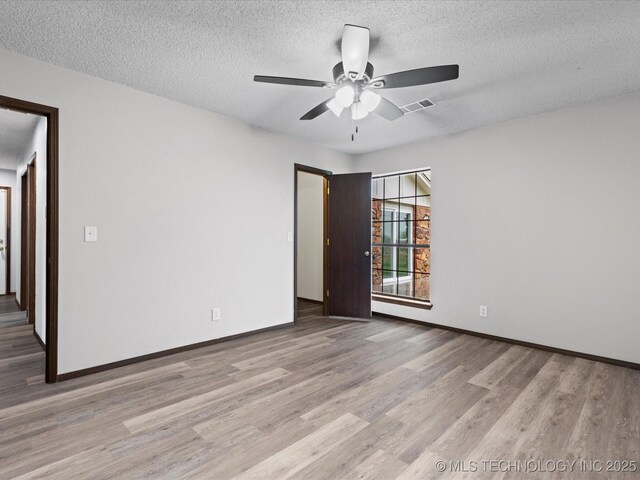 208 NE Spruce Ave, Bartlesville, OK 74006 - spare room with baseboards, ceiling fan, visible vents, and wood finished floors