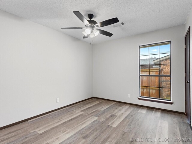 208 NE Spruce Ave, Bartlesville, OK 74006 - empty room featuring wood finished floors, baseboards, ceiling fan, and visible vents