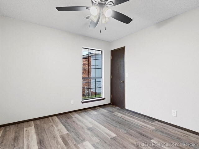 208 NE Spruce Ave, Bartlesville, OK 74006 - empty room featuring a textured ceiling, baseboards, ceiling fan, and wood finished floors