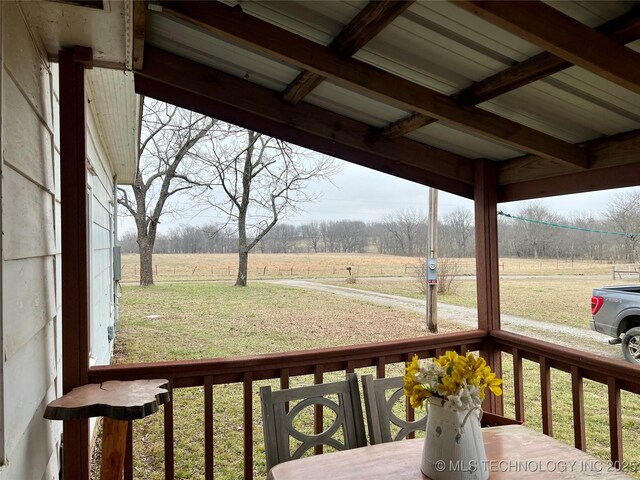 wooden terrace featuring a yard and a rural view