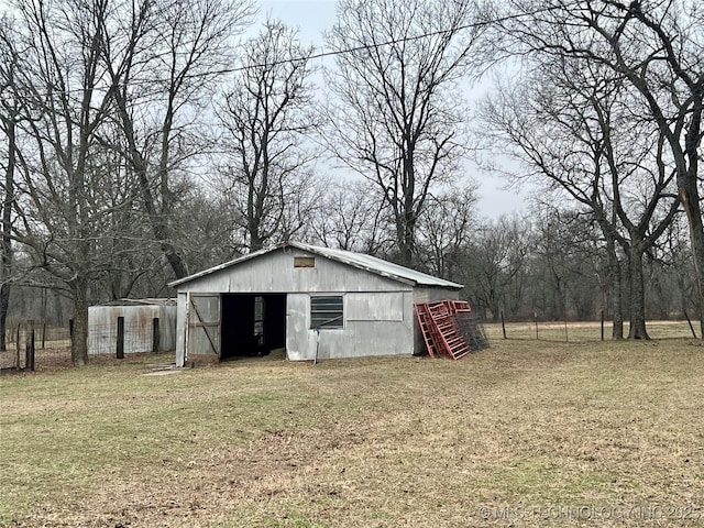 view of pole building with fence and a yard