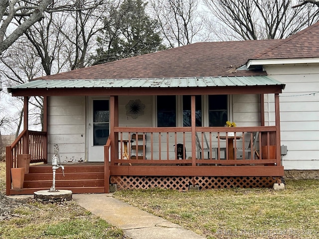 exterior space with covered porch and roof with shingles