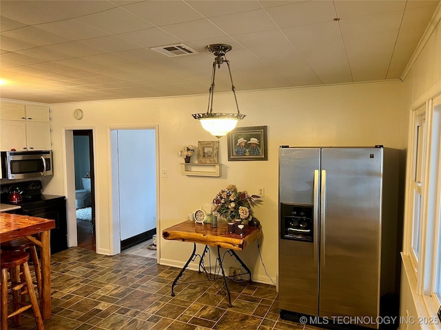 kitchen featuring visible vents, baseboards, ornamental molding, stainless steel appliances, and white cabinetry