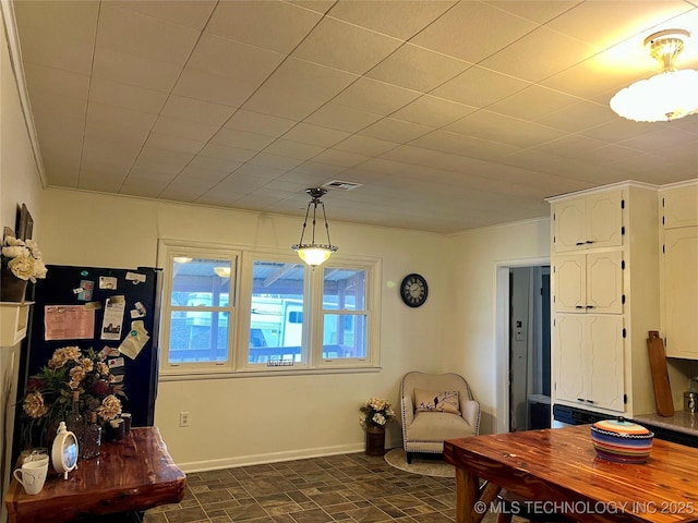 interior space featuring baseboards, visible vents, and ornamental molding