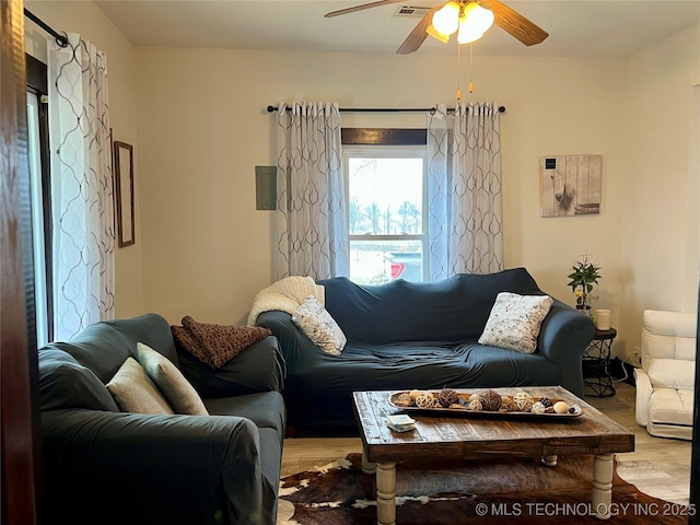 living room featuring visible vents, wood finished floors, and a ceiling fan