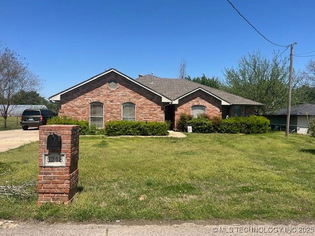 single story home with a front yard and brick siding