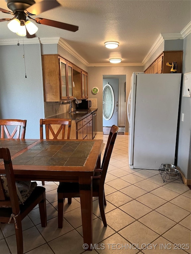 dining space featuring a textured ceiling, crown molding, ceiling fan, and light tile patterned floors