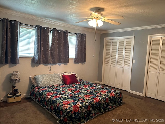 carpeted bedroom with two closets, a textured ceiling, ornamental molding, and multiple windows
