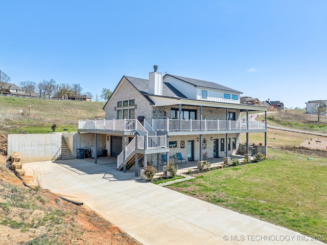 back of property with a lawn, a garage, driveway, and stairs