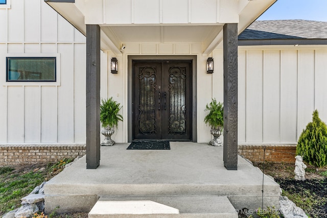 12255 Avalon Dr, Sperry, OK 74073 - property entrance with board and batten siding, a shingled roof, and covered porch