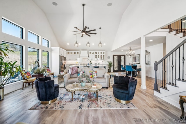 12255 Avalon Dr, Sperry, OK 74073 - living area with a chandelier, stairway, high vaulted ceiling, a ceiling fan, and light wood-style floors