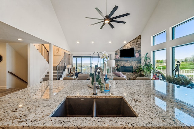 12255 Avalon Dr, Sperry, OK 74073 - kitchen with open floor plan, high vaulted ceiling, ceiling fan, a stone fireplace, and healthy amount of natural light