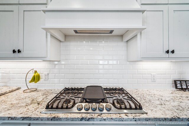 12255 Avalon Dr, Sperry, OK 74073 - kitchen featuring stainless steel gas stovetop, premium range hood, decorative backsplash, and light stone countertops