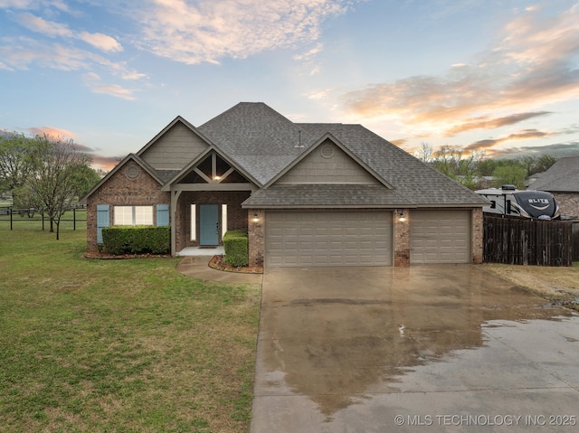 craftsman-style house with a shingled roof, an attached garage, fence, concrete driveway, and a front lawn