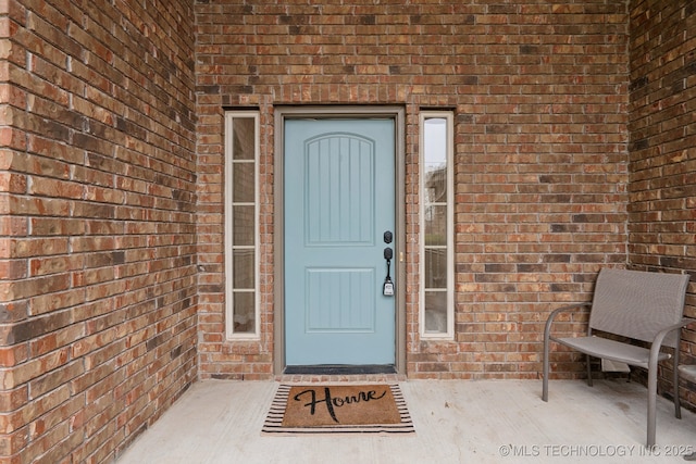 property entrance featuring brick siding