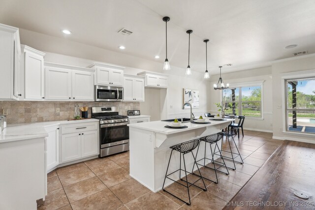 kitchen with light tile patterned flooring, visible vents, a sink, and appliances with stainless steel finishes