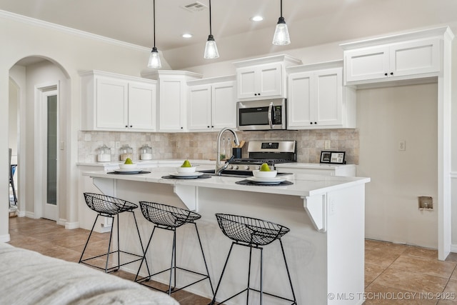 kitchen featuring white cabinetry, backsplash, light countertops, and appliances with stainless steel finishes