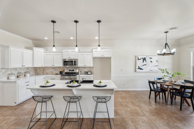 kitchen with stainless steel appliances, tasteful backsplash, light countertops, and white cabinetry