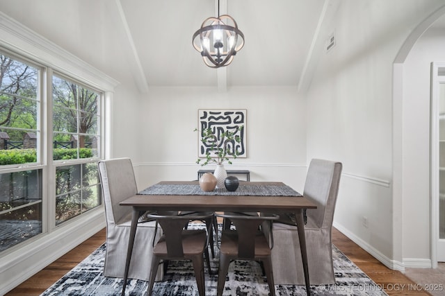 dining space featuring visible vents, arched walkways, an inviting chandelier, beamed ceiling, and wood finished floors