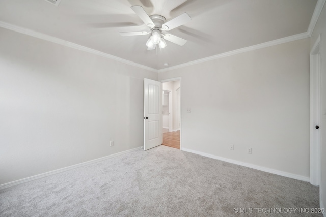 unfurnished room with ornamental molding, carpet flooring, baseboards, and a ceiling fan
