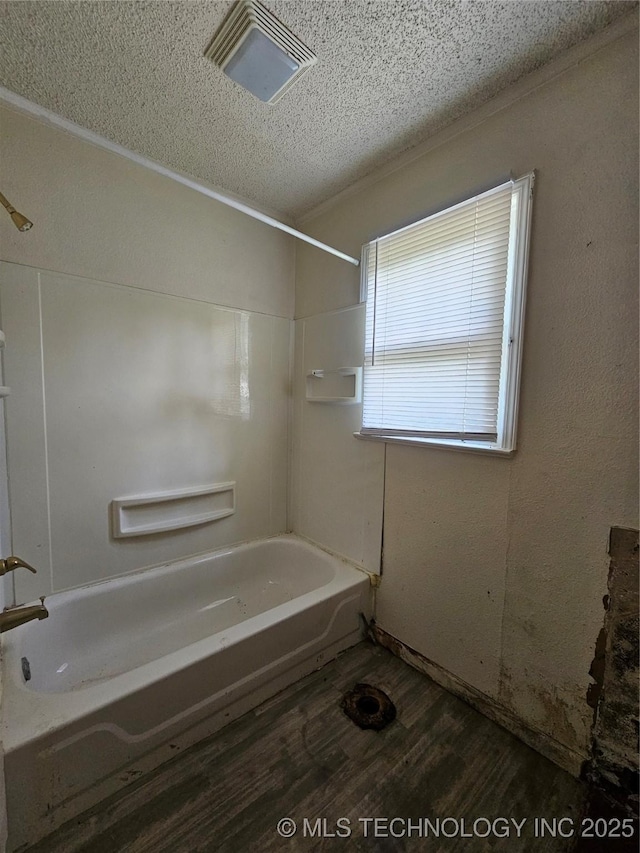 full bath featuring visible vents, wood finished floors, washtub / shower combination, and a textured ceiling