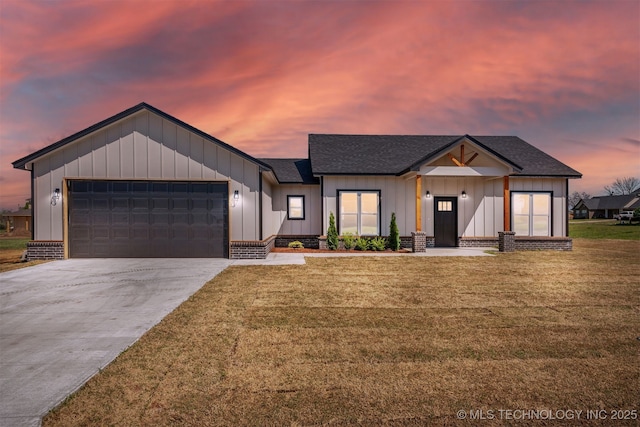 modern inspired farmhouse featuring a yard, an attached garage, board and batten siding, and concrete driveway