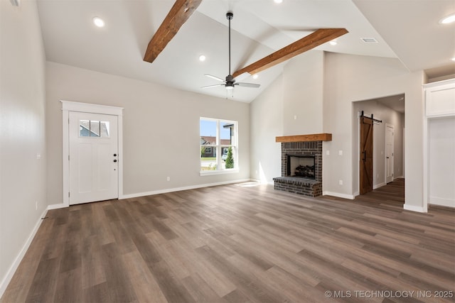 unfurnished living room featuring dark wood-style flooring, baseboards, a ceiling fan, a barn door, and high vaulted ceiling