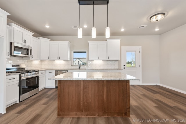 kitchen featuring visible vents, a center island, plenty of natural light, and stainless steel appliances