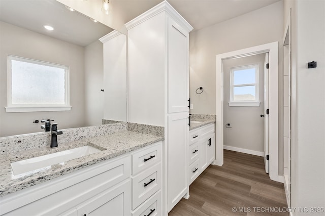 bathroom featuring recessed lighting, vanity, baseboards, and wood finished floors